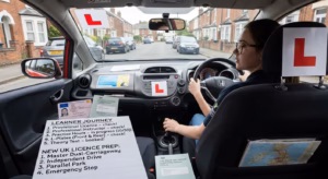 Learner driver practising in a car with an L plate before obtaining a full UK driving licence